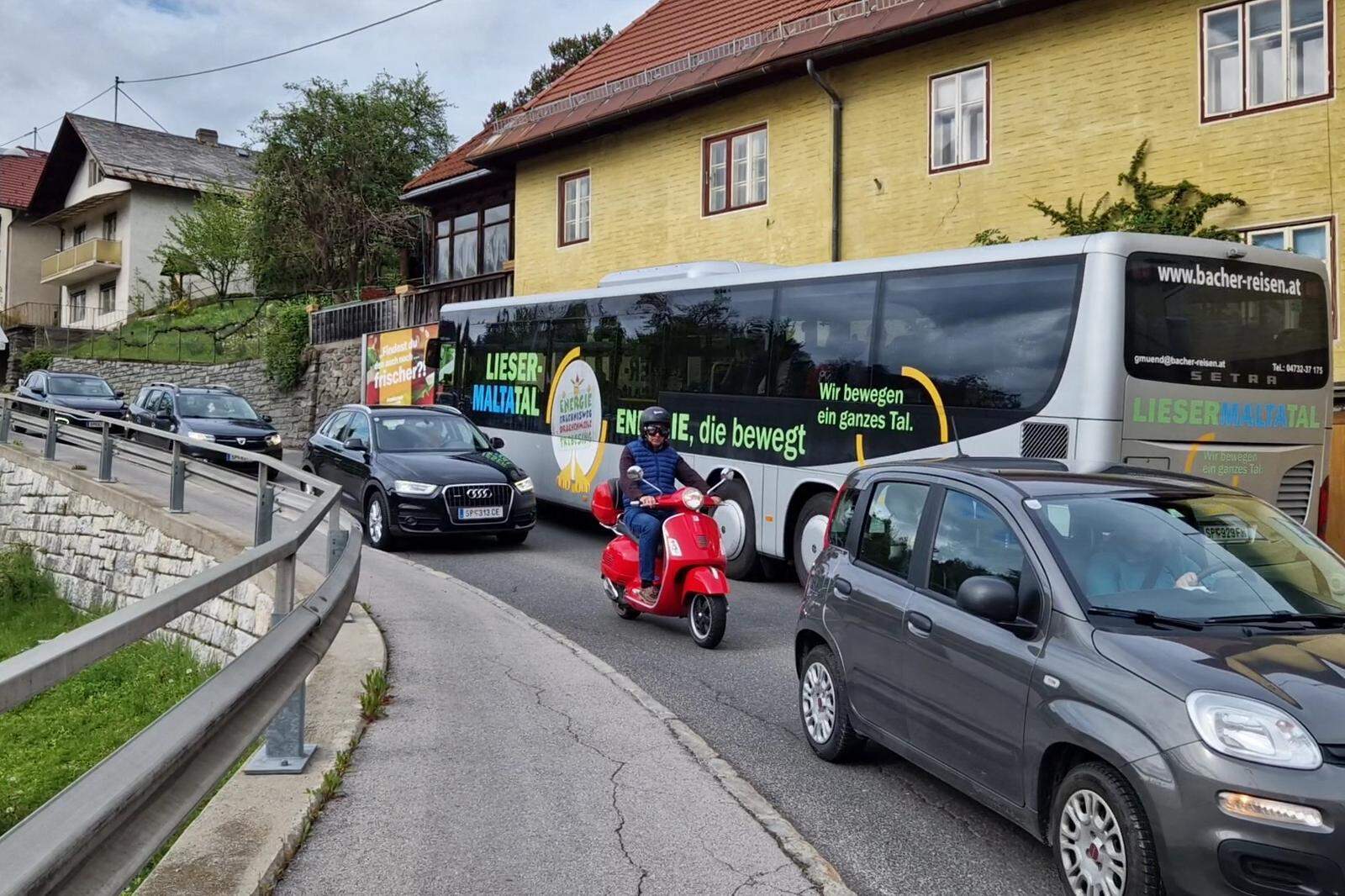 Busse, LKW und PKW schlängeln sich in dichten Abständen zu den Stoßzeiten durch die enge Straße