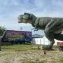 Ein großer Dinosaurier steht auf einer Wiese