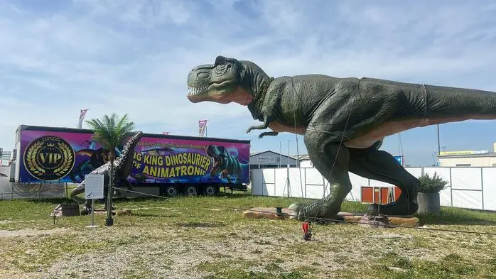 Ein großer Dinosaurier steht auf einer Wiese