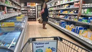 Ein Einkaufswagen zwischen Supermarktregalen | Letzte Einkäufe für die Osterfeiertage sind nicht überall zu den gewohnten Zeiten möglich