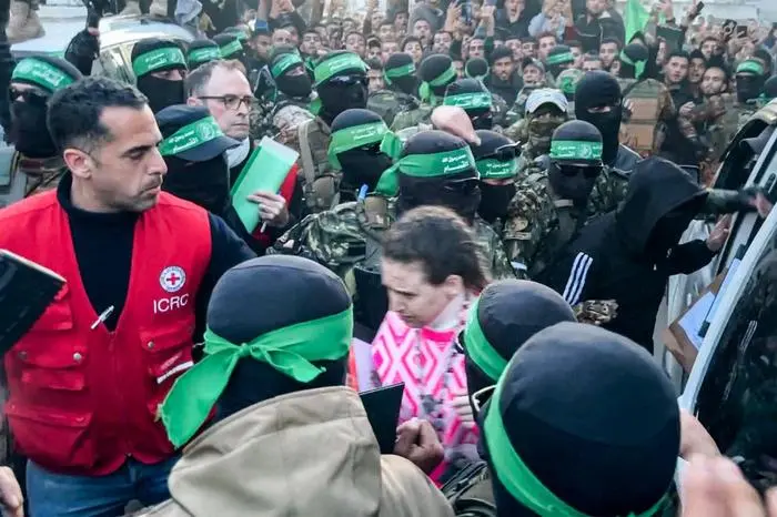 This image grab shows one of the Israeli hostages exiting a vehicle to be handed over to the International Committee of the Red Cross (ICRC) during the hostage-prisoner exchange operation in Saraya Square in western Gaza City on January 19, 2025. The Israeli military said the Red Cross had confirmed the handover of three hostages on January 19, the first to be released as part of a ceasefire deal with Hamas. The Hostage and Missing Families Forum campaign group had identified the three women set to be released as Emily Damari, Romi Gonen and Doron Steinbrecher, seized during Hamas's October 7, 2023 attack that triggered the war. (Photo by AFP)