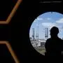An employee stands in front of windows on a deck of the MSC World Europa ocean liner, which is under construction in a dry dock of the "Chantier de l'Atlantique" shipyard in Saint-Nazaire, western France. - The MSC World Europa is the first ocean liner propelled with liquefied natural gas (LNG) built in France. (Photo by Loic VENANCE / AFP)