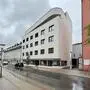 Seitlicher Blick auf ein weißes mehrstöckiges Innenstadtgebäude