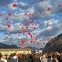Rote Luftballons steigen bei der Trauerfeier am Flugplatz Nikolsdorf in die Luft