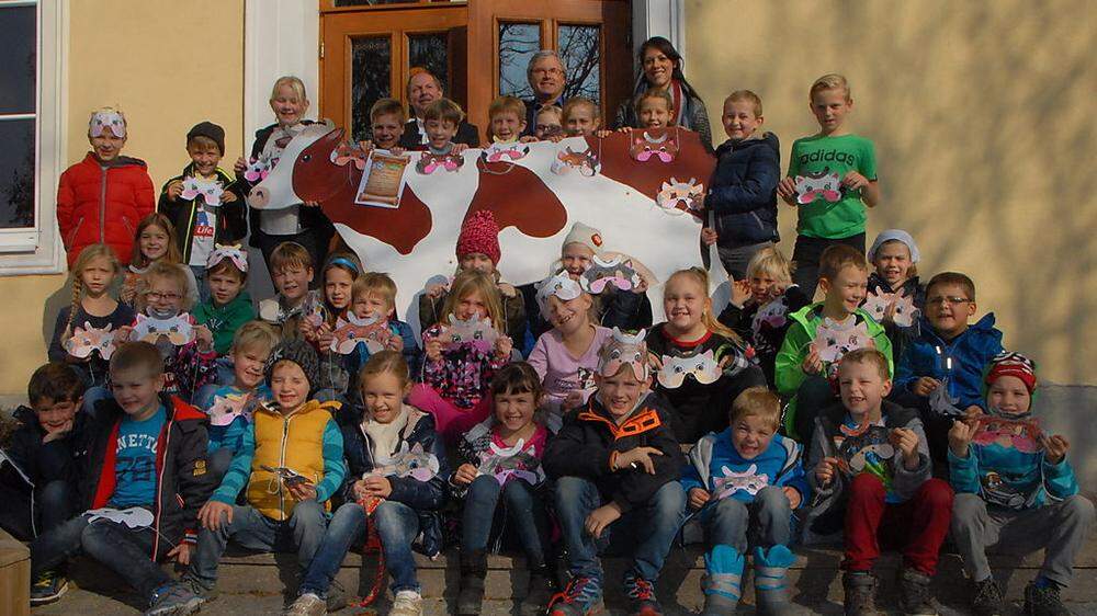 Die Lödersdorfer Volksschüler mit Kuh und Kuhmasken freuen sich über die Belohnung ihrer Arbeit