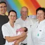 Ein Foto aus dem Archiv: Primarius Hannes Hofmann mit seinem Team und einem Neugeborenen