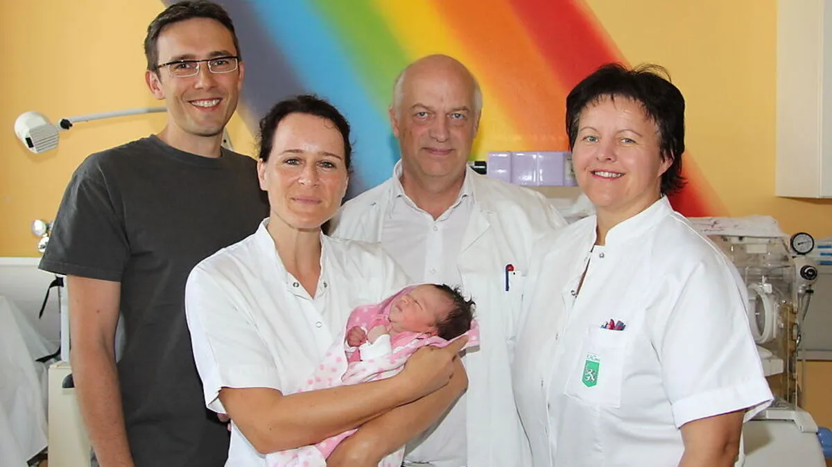 Ein Foto aus dem Archiv: Primarius Hannes Hofmann mit seinem Team und einem Neugeborenen