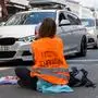 Augsburg, Bavaria, Germany - August 3, 2024: A Last Generation activist blocks traffic in Augsburg to draw attention to the urgency of climate protection *** Ein Aktivist der Letzten Generation blockiert den Straßenverkehr in Augsburg, um auf die Dringlichkeit des Klimaschutzes aufmerksam zu machen