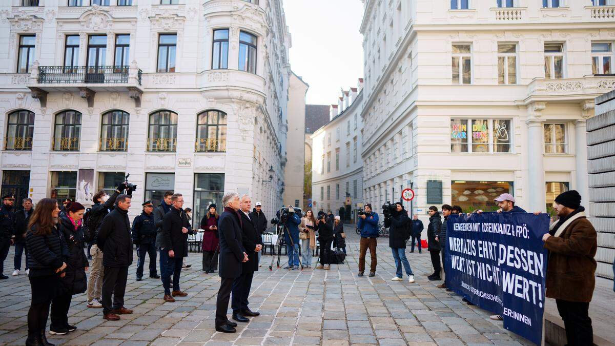 Parlamentsdirektor Harald Dossi und Nationalratspräsident Walter Rosenkranz (FPÖ) vor den Demonstranten am Judenplatz