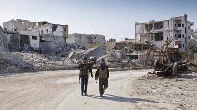 Kurdische Kämpfer in der zerstörten Stadt