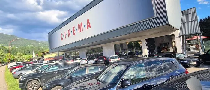 Am Bild sieht man ein Kino und viele parkende Autos