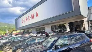 Am Bild sieht man ein Kino und viele parkende Autos   