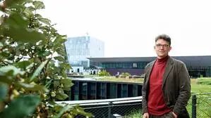 Philipp Pointner steht,  mit einer Hand in die Hosentasche eingesteckt, und blickt in die Kamera. Im Hintergrund die Stadthalle