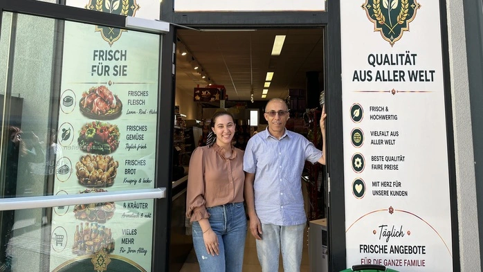 Vater und Tochter stehen im Eingang zum Geschäft