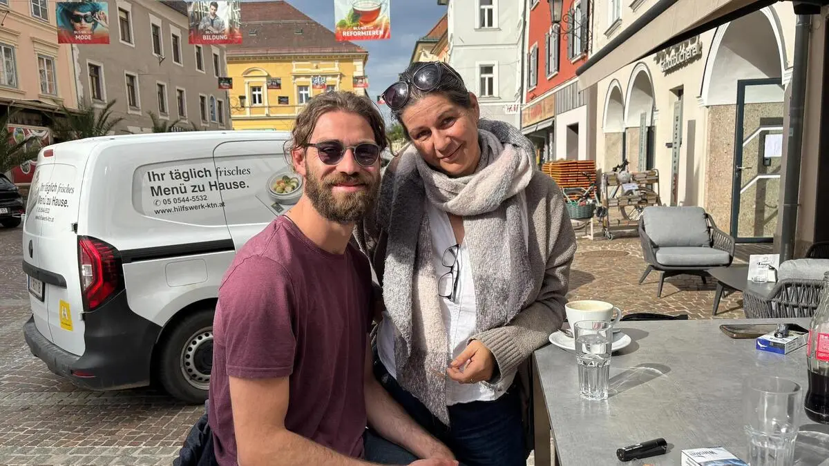 Eine Frau, Ende 40, und ihr 25-jähriger Sohn, der einen Bart und eine Sonnenbrille hat.