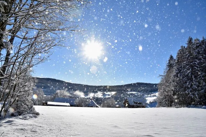 Zauberhaftes Miesenbach mit Sonne und Schneeflocken.
