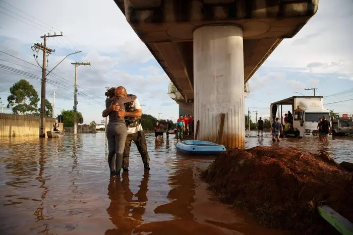 Das Wasser steht hüfthoch und die Brasilianer und Brasilianerinnen versuchen sich selbst und ihr Hab und Gut zu retten. 