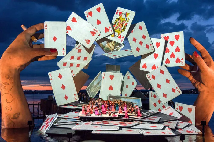 Dreh- und Angelpunkt ihrer Bühnenkonstruktion sind zwei überdimensionale Hände mit Höhen von 21 und 18 Metern, zwischen denen riesige Spielkarten durch die Luft wirbeln.