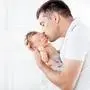 Father holding his newborn baby in  hands. Father kissing his baby