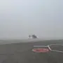 Ein Hubschrauber steht im Nebel auf einem Flughafen | Der Hubschrauber RK1 ist am Flughafen Klagenfurt gelandet