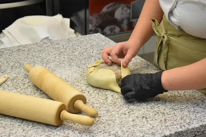 Die Füllung wird von den Schülerinnen in Germteig verpackt