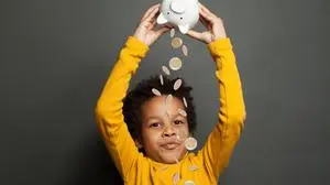 Happy black child and money rain on black background