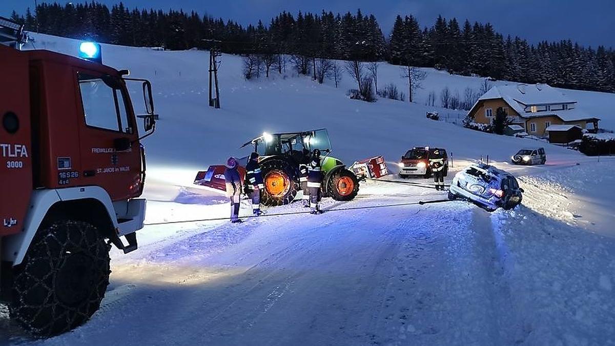 Feuerwehrfahrzeug und Traktor zogen gemeinsam den Pkw wieder zurück auf die Straße