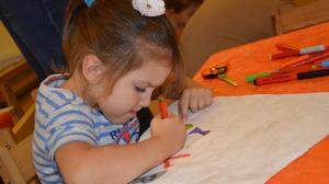 Lilly Loder voll konzentriert beim Drachenbasteln mit ihrem Papa im Eltern-Kind-Zentrum Weiz