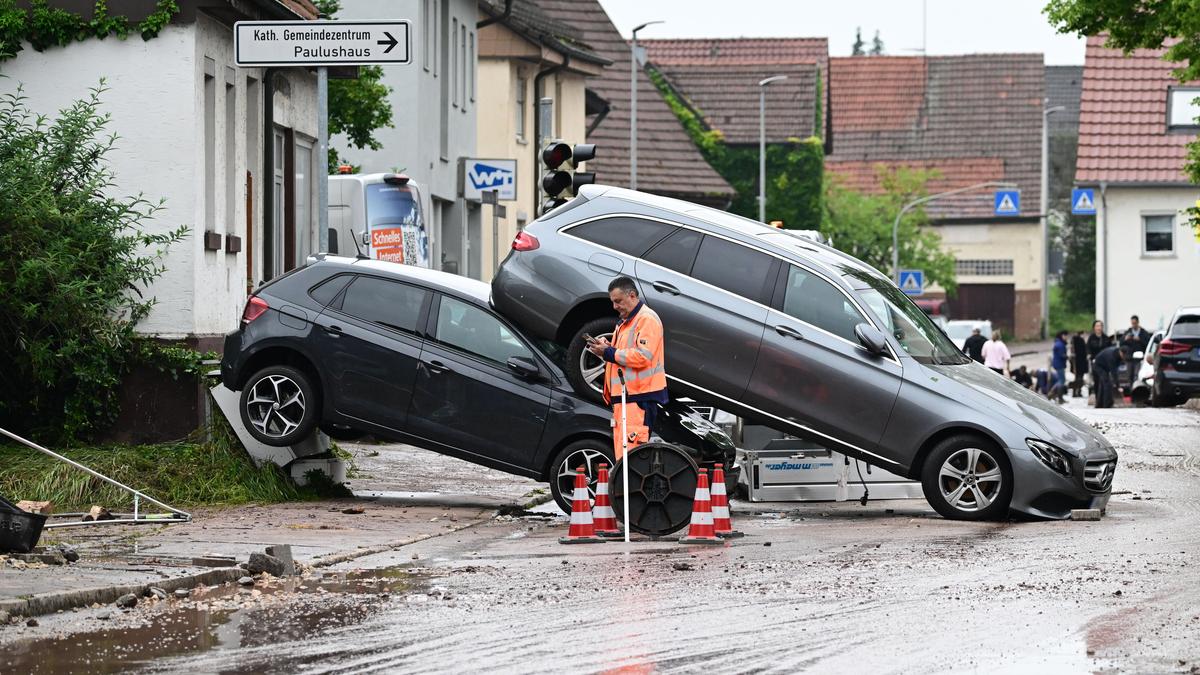 Auf einer Straße in Miedelsbach stehen Fahrzeuge, die durch ein Hochwasser nach einem Unwetter weggespült wurden. Seit Tagen kämpfen die Helfer in Bayern und Baden-Württemberg gegen die Flut und ihre Folgen