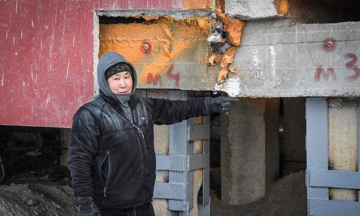 Bauarbeiter Eduard Romanov zeigt die Schäden an den Gebäuden