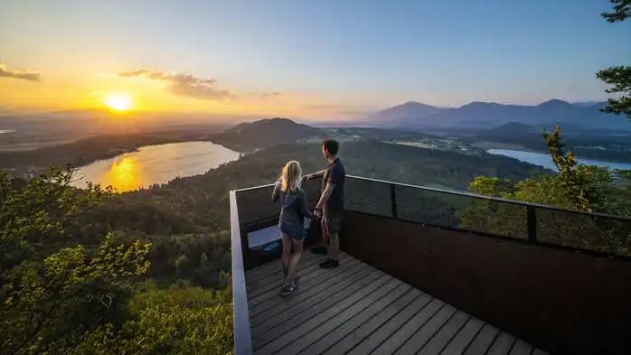 2 Personen beobachten Sonnenuntergang von Aussichtsplattform
