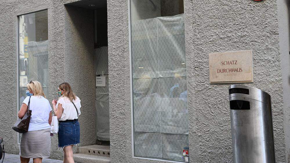 Zwei Frauen gehen an einem leer stehenden Geschäftslokal in Salzburg vorbei.