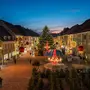Aufnahme einer europäischen Altstadt. Im Zentrum steht ein großer Christbaum. Alles ist festlich geschmückt. Die letzte Phase der Abenddämmerung hat bereits eingesetzt und färbt den Himmel dunkelblau bis violett. | Der St. Veiter Weihnachtsmarkt startet am 28. November