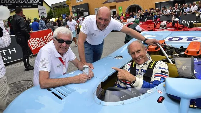 Die Ennstal-Classic-Chefs Helmut Zwickl und Michael Glöckner mit Hans Joachim Stuck im legendären Le Mans-Porsche