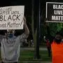 Protestors hold signs outside the County Courthouse during demonstrations against the shooting of Jacob Blake in Kenosha, Wisconsin on August 25, 2020. - Jacob Blake, Jr., was shot several times by police may be permanently paralyzed, his family said on August 25. Blake was shot August 23 by a white policeman while getting into a car that held his three children after trying to break up a domestic dispute, according to civil rights attorney Benjamin Crump, who is representing the Blake family. (Photo by KAMIL KRZACZYNSKI / AFP)