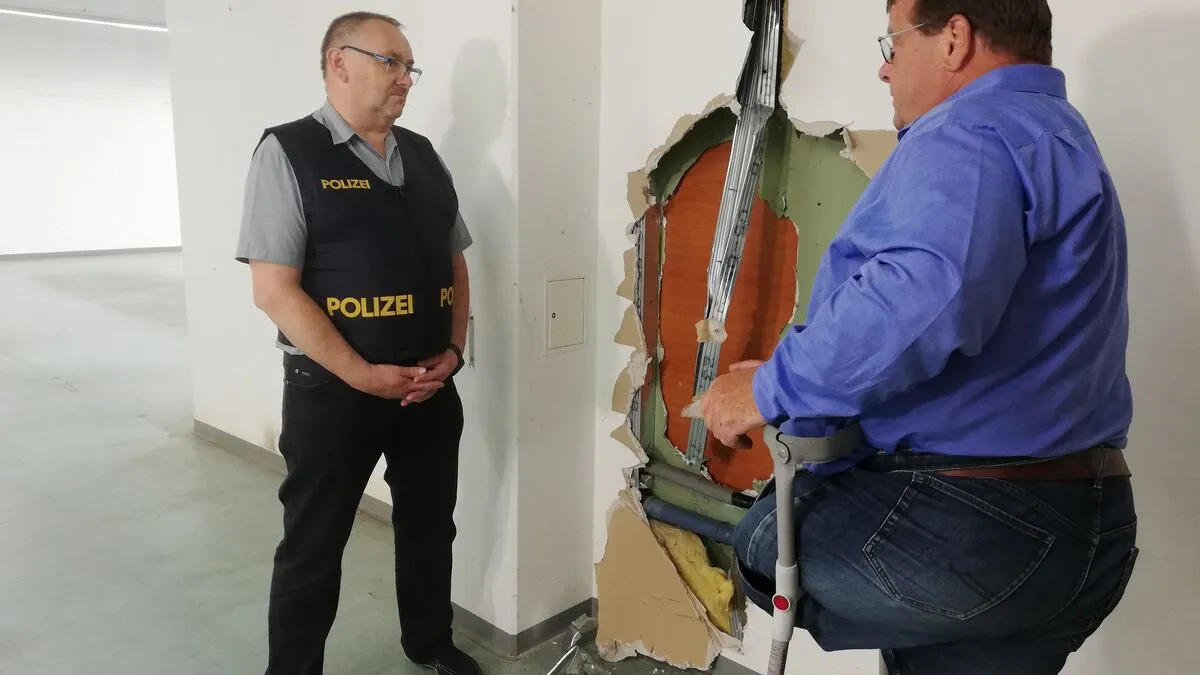 Gruppeninspektor Thomas Schwarzenberger mit dem Trafikanten Günter Uhl vor der Wand, die die Diebe durchbrochen haben