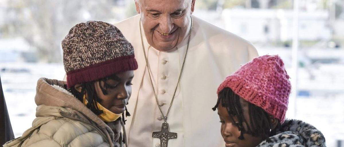 Papst Franziskus spricht mit zwei Flüchtlingskindern auf Lesbos