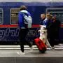 Pedestrians walk past the Berlin-Paris night "train night-jet" during its launch at the main station in Berlin, on December 11, 2023. A new sleeper service between Berlin and Paris will set off from the German capital on December 11, 2023 evening after a decade-long hiatus, as night trains gain in popularity as an alternative to short-haul flights. The connection will be operated by French and German national train operators SNCF and Deutsche Bahn, while the rolling stock will be provided by Austrian train company OeBB, whose "Nightjet" trains already criss-cross central Europe. (Photo by MICHELE TANTUSSI / AFP)