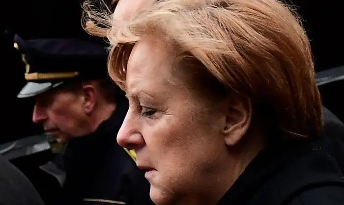 German Chancellor Angela Merkel (C)and German Foreign Minister Frank-Walter Steinmeier (L) walk through the Christmas market of the Kaiser-Wilhelm-Gedaechtniskirche (Kaiser Wilhelm Memorial Church), the day after an attack at the nearby Christmas market in central Berlin, on December 20, 2016.
German police said they were treating as 