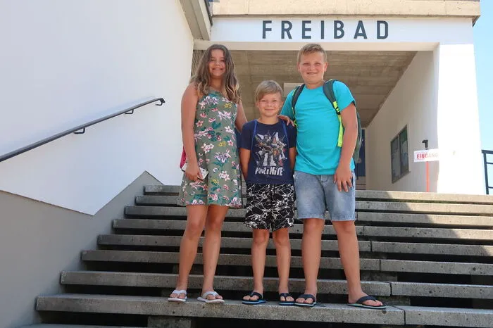 Lena und Maximilian Kreditsch verbringen den Tag mit Swen Stadler im Freibad. Die Mund-Nasen-Maske haben sie immer griffbreit im Rucksack.
