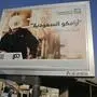 A man walks under a billboard displaying an advertisement for Saudi Arabia's state-owned oil giant Aramco with Arabic reading: "Saudi Aramco, soon on stock exchange" in Jiddah, Saudi Arabia, Tuesday, Nov. 12, 2019. Saudi Aramco is the kingdom's oil and gas producer, pumping more than 10 million barrels of crude oil a day, or some 10% of global demand. (AP Photo/Amr Nabil)