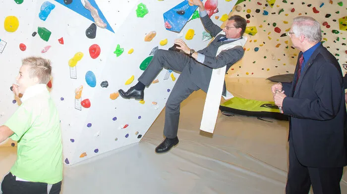 Anno Schulte-Herbrüggen probierte den Boulderraum während der Segnung aus