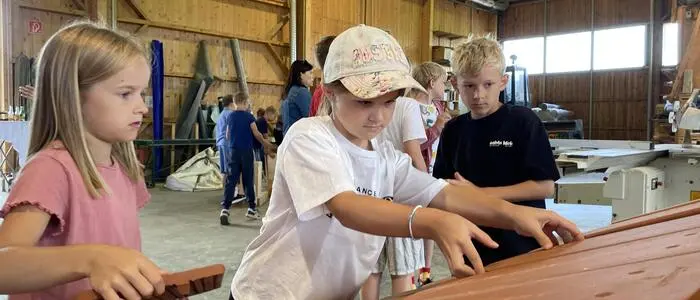Volksschulkinder aus Jagerberg bekommen bei „Volksschule trifft Wirtschaft“ Einblick in viele Betriebe – kürzlich versuchten sie sich bei Lückl Holzbau am Zimmererhandwerk 