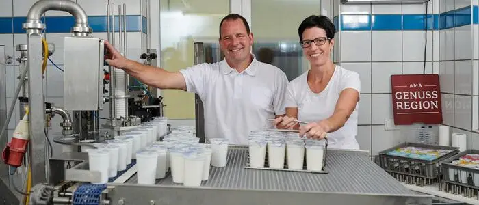 Zwei Menschen mit Milchbehältern