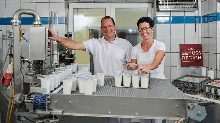 Zwei Menschen mit Milchbehältern