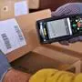 Ein Zusteller scannt ein Paket | Eine neue Paketsteuer soll die geplante Entlastung bei Grundnahrungsmitteln gegenfinanzieren, was auf Kritik stößt