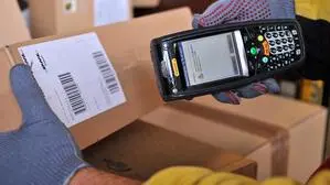 Ein Zusteller scannt ein Paket | Eine neue Paketsteuer soll die geplante Entlastung bei Grundnahrungsmitteln gegenfinanzieren, was auf Kritik stößt