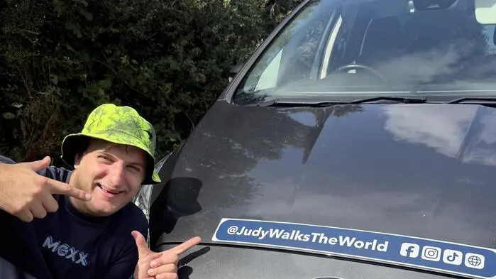 Ein Mann kniet vor einem Auto