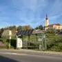 Foto der Bushaltestelle in St. Veit, mit der Kirche im Hintergrund