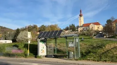 Foto der Bushaltestelle in St. Veit, mit der Kirche im Hintergrund
